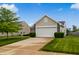 Traditional home with well-kept lawn, mature tree, and two-car garage at 2138 Rossington Ln, Indianapolis, IN 46229