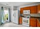 Bright kitchen featuring wood cabinets, white appliances, and a large window at 2138 Rossington Ln, Indianapolis, IN 46229
