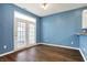Bright dining area featuring a large window, hardwood floors, and a calming, modern blue wall at 2270 Brightwell Pl, Indianapolis, IN 46260