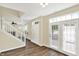 Bright foyer with wood floors, white staircase, and a door to the backyard at 2270 Brightwell Pl, Indianapolis, IN 46260