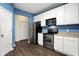 Well-lit kitchen showcasing stainless steel appliances and sleek white cabinetry against blue walls at 2270 Brightwell Pl, Indianapolis, IN 46260