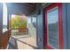 Exterior shot of a covered wooden balcony featuring a red door and gray siding at 2302 Prospect St, Indianapolis, IN 46203