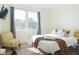 Well-lit bedroom showcasing a comfortable queen bed, hardwood floors, and a stylish accent chair at 2302 Prospect St, Indianapolis, IN 46203