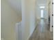 This is a long hallway with hardwood floors, white paint, a white front door, and a staircase at 2302 Prospect St, Indianapolis, IN 46203