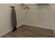 This is a view of an empty laundry room with a wire rack, ironing board, and hardwood floors at 2302 Prospect St, Indianapolis, IN 46203