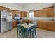 Well-lit kitchen featuring wooden cabinets, stainless steel appliances, and a small dining table at 2427 Apple Tree Ln, Indianapolis, IN 46229