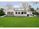A well-manicured backyard with a patio set and stone-accented exterior featuring large picture windows at 2428 Hawthorn Pl, Noblesville, IN 46062