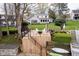 A serene backyard showcasing a wooden deck, steps to the lake, and a lush lawn surrounded by mature trees at 2428 Hawthorn Pl, Noblesville, IN 46062