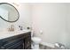 Clean half bathroom with a vanity sink, white toilet, and neutral decor at 2428 Hawthorn Pl, Noblesville, IN 46062