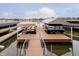 A waterfront view of a wooden boat dock and boat with coverings on a lake in a residential neighborhood at 2428 Hawthorn Pl, Noblesville, IN 46062