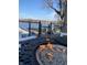 Relaxing outdoor space with a modern fire pit on a deck, overlooking a serene lake with boat docks at 2428 Hawthorn Pl, Noblesville, IN 46062