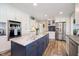 Gorgeous kitchen with a blue island, white cabinets, stainless steel appliances, and wood flooring at 2428 Hawthorn Pl, Noblesville, IN 46062