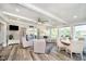 Sunlit living room with floor to ceiling windows and a view to the backyard patio and water beyond at 2428 Hawthorn Pl, Noblesville, IN 46062