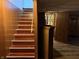 Basement stairs with wood paneling lead to an open doorway and finished floors at 244 E Cragmont Dr, Indianapolis, IN 46227