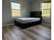 This bedroom has two large windows and wood-look flooring at 244 E Cragmont Dr, Indianapolis, IN 46227