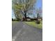 Long driveway leading to a brick home surrounded by mature trees and lush green lawn at 244 E Cragmont Dr, Indianapolis, IN 46227