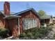 A brick home with blue trim and shutters, showcasing a classic design and manicured flowerbeds at 244 E Cragmont Dr, Indianapolis, IN 46227