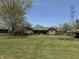 Well-maintained brick home set back from the road, surrounded by a green lawn and mature trees at 244 E Cragmont Dr, Indianapolis, IN 46227