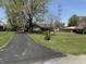 Home with a long driveway and large trees, with powerlines in the background on a sunny day at 244 E Cragmont Dr, Indianapolis, IN 46227