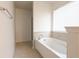 Bathroom featuring a soaking tub with tile surround and a window for natural light at 2545 Coneflower Ct, Columbus, IN 47201