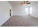Bright bedroom featuring neutral carpet, a ceiling fan, and double windows for ample natural light at 2545 Coneflower Ct, Columbus, IN 47201