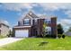 Charming two-story brick home with manicured lawn, and a two car garage under a cloudy blue sky at 2545 Coneflower Ct, Columbus, IN 47201