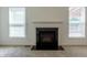 A gas fireplace with black hearth is framed by white trim and two windows at 2545 Coneflower Ct, Columbus, IN 47201