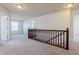 Hallway with neutral carpet and wood banister overlooking open space and natural light at 2545 Coneflower Ct, Columbus, IN 47201