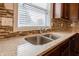 Stainless steel sink and stone countertops in a kitchen, framed by backsplash and cabinets at 2545 Coneflower Ct, Columbus, IN 47201