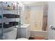 Clean bathroom featuring a shower-tub combo with stylish curtain and gray storage shelves for ample storage space at 2822 Walker Ave, Indianapolis, IN 46203