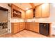 The basement includes a bar area with wood cabinets and a mini fridge at 3413 Putter Pl, Columbus, IN 47203