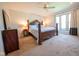 This bedroom showcases a decorative wooden bed, dresser, ceiling fan, and bright natural light at 3413 Putter Pl, Columbus, IN 47203