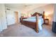 Spacious main bedroom featuring a large bed with decorative posts and access to the ensuite bathroom at 3413 Putter Pl, Columbus, IN 47203