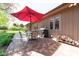 Outdoor patio with brick flooring, dining set with umbrella, grill, and stack of wood, perfect for entertaining at 3413 Putter Pl, Columbus, IN 47203
