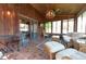 Bright sunroom features wood paneled walls, tile flooring, and comfortable wicker seating at 3413 Putter Pl, Columbus, IN 47203