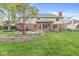 Inviting backyard featuring a stone-accented flower bed and patio, surrounded by a lush lawn at 3790 Steeplechase Dr, Carmel, IN 46032