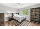 Stylish bedroom features ceiling fan, wood floors, a bookshelf, and large window offering natural light at 3790 Steeplechase Dr, Carmel, IN 46032