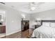 Serene bedroom with wood floor features a dresser and a nightstand with lamp at 3790 Steeplechase Dr, Carmel, IN 46032