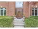 Elegant front entrance featuring a wooden door, decorative flower pots, and a well-manicured landscape at 3790 Steeplechase Dr, Carmel, IN 46032