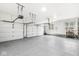 Spacious garage with epoxy flooring, multiple car doors, and organization system at 3790 Steeplechase Dr, Carmel, IN 46032