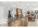 Spacious kitchen island with granite countertop and wood cabinets open to dining and living spaces at 3790 Steeplechase Dr, Carmel, IN 46032