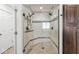 Updated shower featuring glass door, white subway tile, mosaic accents, bench, and a rainfall shower head at 3790 Steeplechase Dr, Carmel, IN 46032