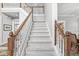 Bright, carpeted staircase with white and wooden banisters leading to the second floor at 3790 Steeplechase Dr, Carmel, IN 46032