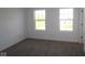 Bright bedroom with neutral carpet, white trim, and two windows offering plenty of natural light at 3832 Highcrest Rd, Indianapolis, IN 46239