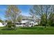 Expansive backyard with a covered porch, a white picket fence and mature trees at 4243 Bay Leaf Cir, Indianapolis, IN 46237