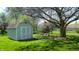 Backyard shed with garden bed featuring flower bed with blooming flowers and a mature tree at 4243 Bay Leaf Cir, Indianapolis, IN 46237