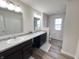 Bathroom featuring double sinks, granite countertops, dark cabinets, and wood-look flooring adds style and convenience at 4245 W Fork Dr, Westfield, IN 46062