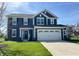 Two-story home with a two-car garage, dark siding, white trim, and a well-manicured lawn at 4245 W Fork Dr, Westfield, IN 46062