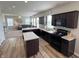 Modern kitchen featuring dark cabinets, granite countertops, an island, and an open floor plan at 4245 W Fork Dr, Westfield, IN 46062