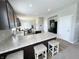 A kitchen with dark cabinets, granite countertops, an island with seating, and stainless steel refrigerator at 4245 W Fork Dr, Westfield, IN 46062